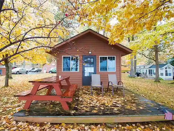 One of the Pioneer cottages with its deck and picnic table among autumn trees