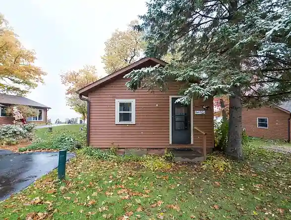 A Pioneer cottage seen from the lawn in fall color