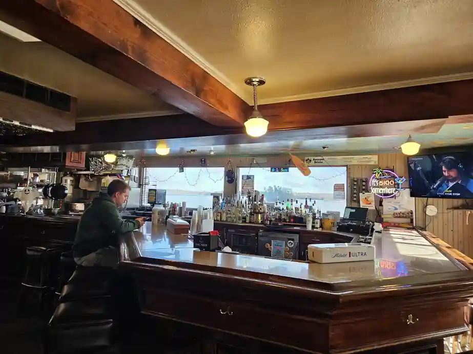 The Pioneer bar with timber ceiling beams and windows looking out on Long Lake