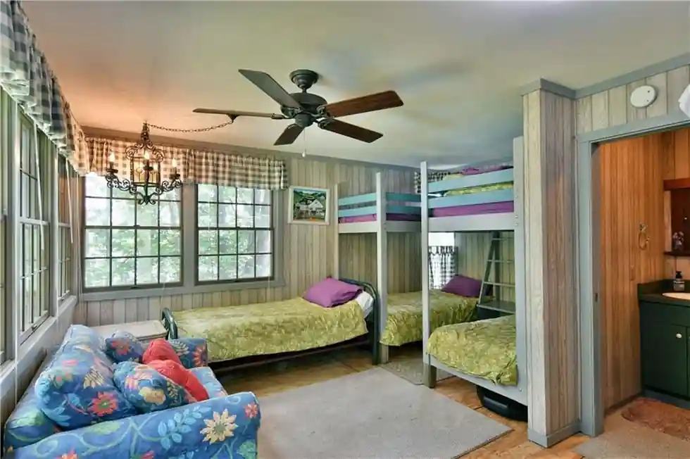 The attached bunkhouse with two sets of bunks, a sofa and a ceiling fan
