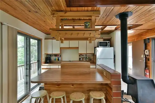 The Island Cabin kitchen with a wood ceiling and an island bar
