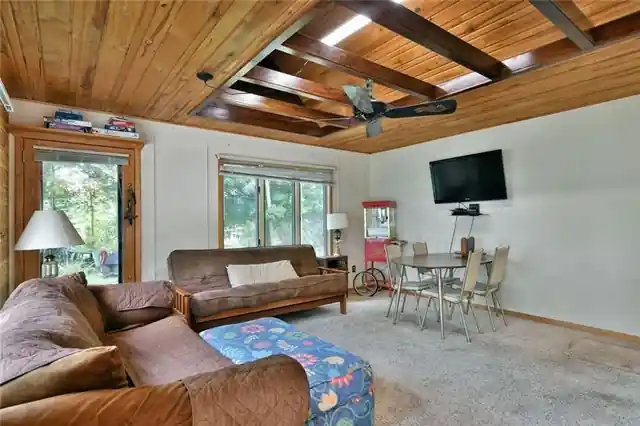 The Island Cabin living room with a beamed ceiling and a TV