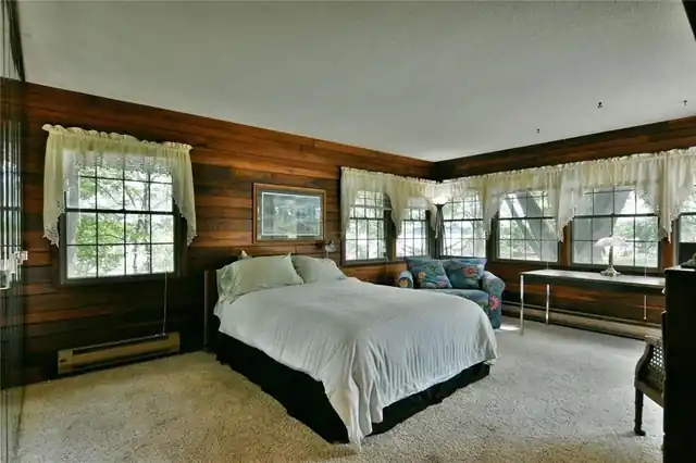 The master bedroom in knotty pine with windows toward the lake